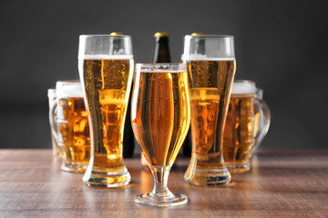 Glassware with fresh beer on wooden table