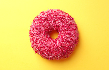 Delicious pink donut on color background