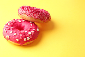 Fototapeta na wymiar Delicious pink donuts on color background