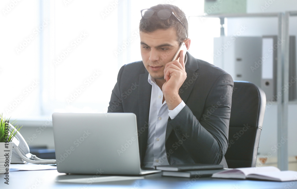 Poster Young man in office wear talking on phone at workplace