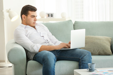 Young man working with laptop in home office