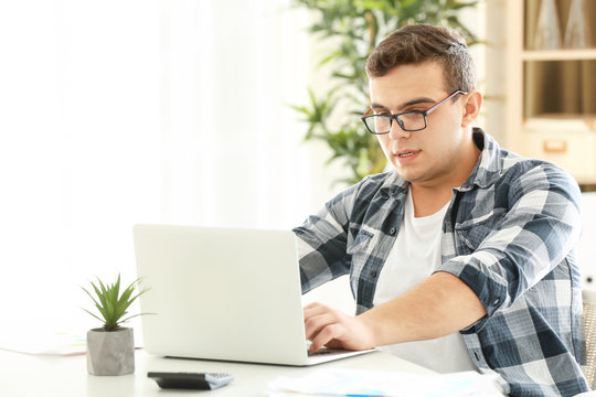 Young man working with laptop in home office