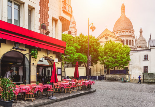 Fototapeta Cozy street with tables of cafe in quarter Montmartre in Paris, France