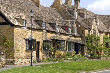 Fototapeta na wymiar A row of pretty honey coloured stone cottages in Broadway, Worcestershire, Cotswolds, UK