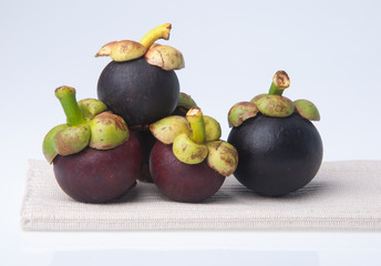 Mangosteen fruit and cross section showing the thick purple skin and white flesh of the queen of fruits.