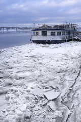 The old steamship in the ice of the river
