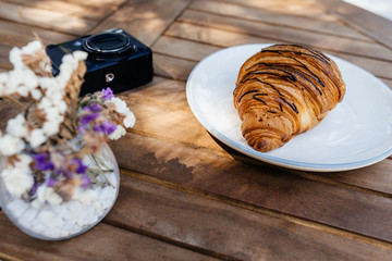 Coffee cup and fresh baked croissants on wooden background. Top View.