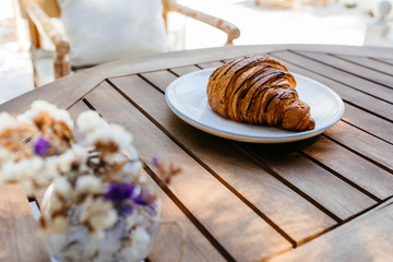 Coffee cup and fresh baked croissants on wooden background. Top View.