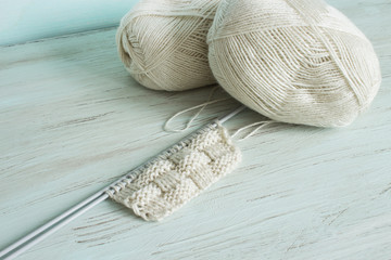 Knitting from light threads on a blue background. Scandinavian style.