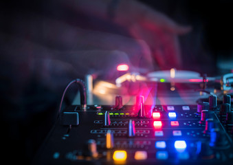 DJ in a Club with Turntables and Mixer