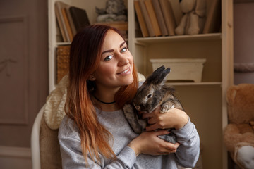 Happy woman holding Easter bunny and smiling to camera at Easter day