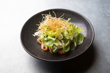 Squid salad served on a black plate