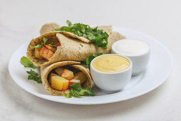 Vegetarian masala dosa with potato, chutney and sambar sauces.