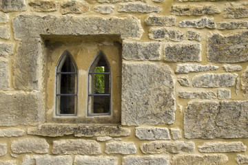 Naklejka premium An ancient window in a stone house wall