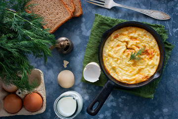 Potato casserole in a cast-iron frying pan on a wooden table, horizontal