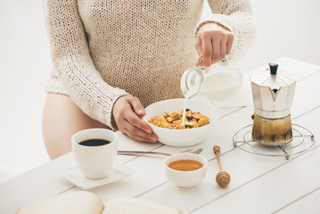 Woman having breakfast. Window light
