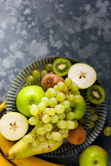 Fresh green fruits - kiwi, green apple, pear, grapes, bananas, top view, selective focus