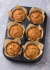 Homemade buckwheat muffins with dried fruits on a gray background, top view