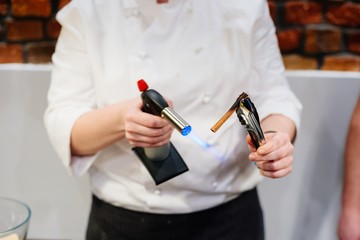 Woman cook heats cinnamon to get more aroma