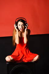 Naklejka premium Girl with loose hair wears headphones. Singer with surprised face