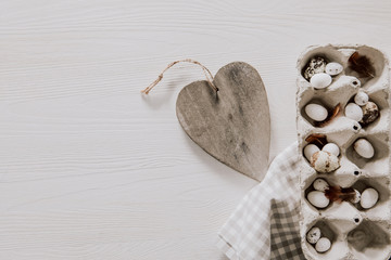 Simple decoration with wooden heart and egg box with napkin on wooden table