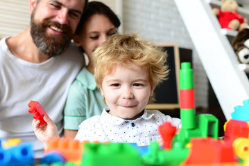 Obraz premium Parents look at son with happy face making brick constructions