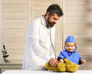 Vet and assistant examine teddy bear. Treatment and medical education