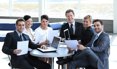 group of business people with documents sitting at a table in the lobby of the Bank.