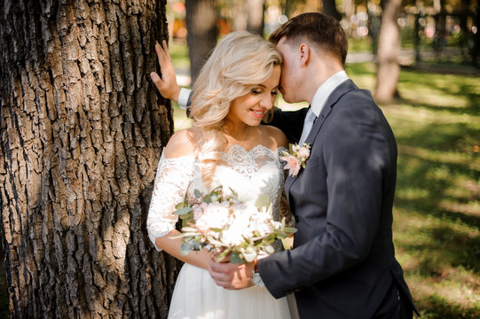 Portrait of a bridegroom kissing a blonde bride