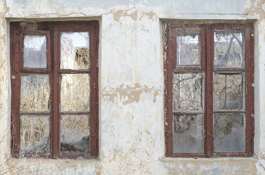 two old abandoned windows with broken glass