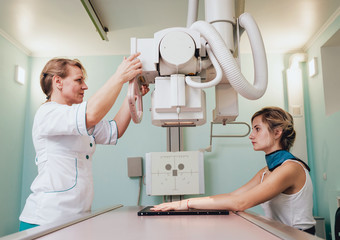 Radiologist and patient in a x-ray room. Classic ceiling-mounted x-ray system.