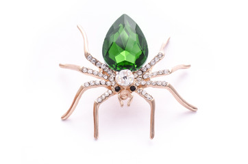 Golden spider with a big green stone isolated on white