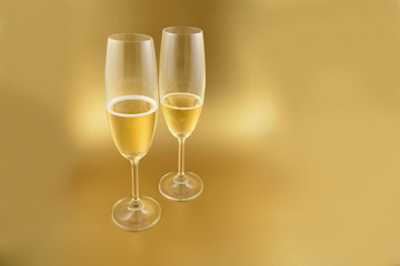 Glass with champagne stock images. Glass with champagne on a golden background. Champagne on a golden background with copy space for text. Festive golden background