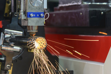 The fiber laser cutting machine cutting the steel pipe with the sparking light.