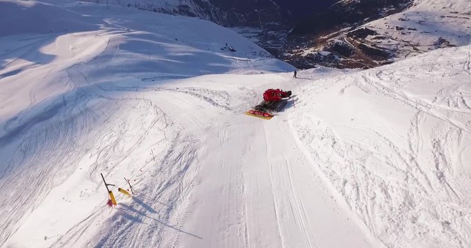 Drone shot of a snow groomer working on the ski slopes of a Swiss Alpine resort