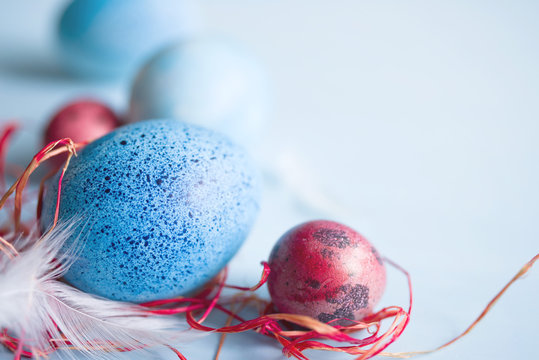 Blue and red Easter eggs on blue background, soft focus