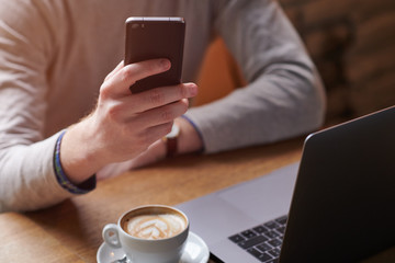 Man drinking coffee while working from coffee shop