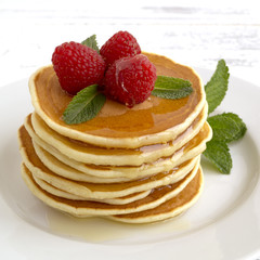 American pancakes with berries on a light background.