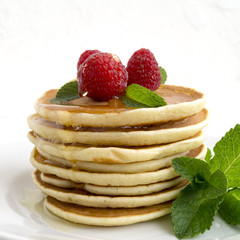American pancakes with berries on a light background.