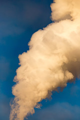 smoke from a pipe in the factory against a blue sky