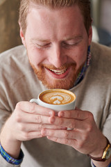 Young man enjoying coffee in coffee shop