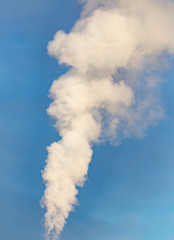 smoke from a pipe in the factory against a blue sky