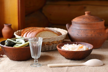 A glass of vodka and a traditional Russian snack.