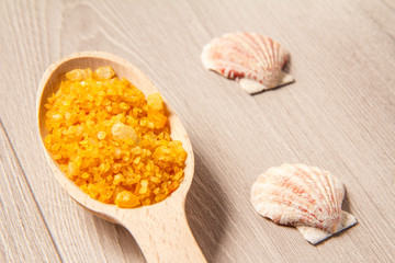 Spa nature products. Wooden spoon with yellow sea salt for bathroom procedures