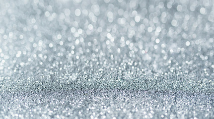 Sparkling festive background. Melting macro snowflakes close up with bokeh at the background. Image with small depth of field. Silver defocused glitter background with copy space.