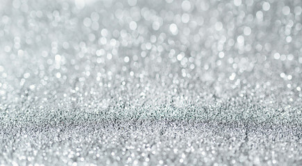 Sparkling festive background. Melting macro snowflakes close up with bokeh at the background. Image with small depth of field. Silver defocused glitter background with copy space.