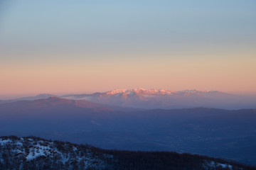 mountains and valley andscape in winter at sunset