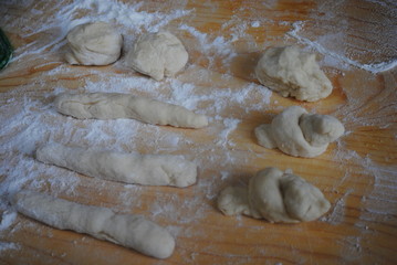 Children's rolling pin for dough. The child kneads the dough with his hands. The baby's hand sifts the flour.