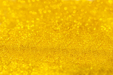 Golden beautiful blurred bokeh background with copy space. Holiday texture. Wallpaper. Glitter light spots on golden background, defocused