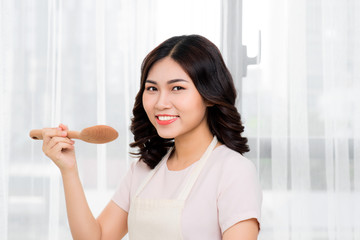 Healthy food. Asian woman cooking in the kitchen with wooden spoon